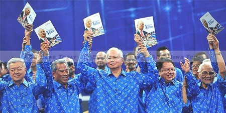 During a Barisan Nasional rally at a stadium in Bukit Jalil, Najib holds a copy of his coalition's election manifesto ahead of upcoming polls