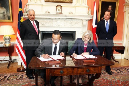 File photo: British Prime Minister David Cameron and Prime Minister Najib Razak look on as Memorandum of Understanding on transnational crime is signed on 14 July 2011