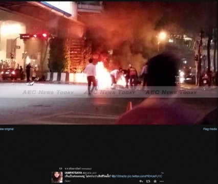 Rescuers rush to burning motorbikes and cars in front of the Erawan shrine in Bangkok