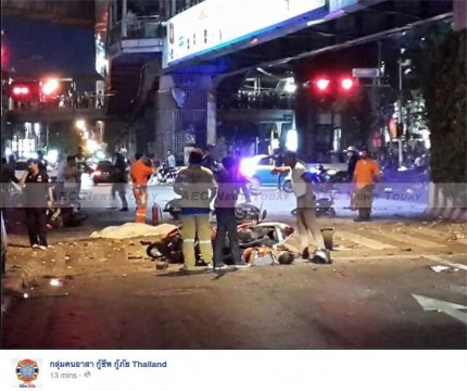 Rescuers move among the injured at Erawan shrine following the Bangkok bomb blast