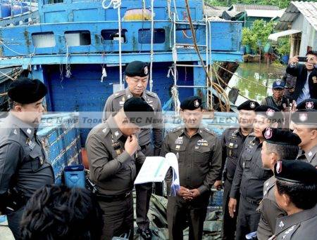 Deputy Police Chief Lieutenant-General Srivara Ransibrahmanakul inspects documents relating to 24 suspected slave fishing boats impounded in Songkhla