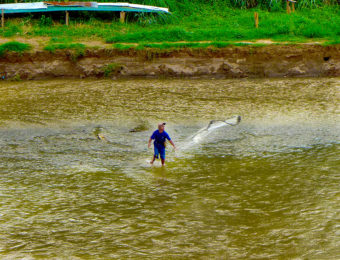 A Kham fisherman casts his net