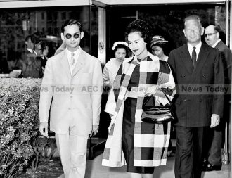 King Bhumibol Adulyadej and Queen Sirikit of Thailand, accompanied by UN Secretary-General Dag Hammarskjöld (right), at the Secretariat entrance as they leave UN Headquarters, at the end their visit, 06 July 1960.