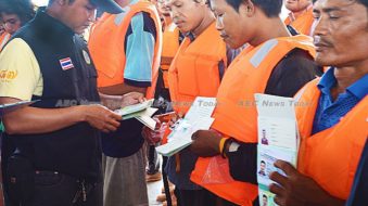 Thai fishers have their identity papers checked leaving and returning to port