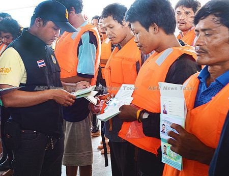 Thai fishers have their identity papers checked leaving and returning to port 
