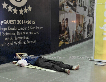 A homeless man sleeps on a sidewalk in Kuala Lumpur, Malaysia